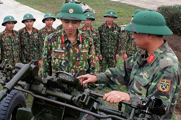 Đồng chí Hoàng Đăng Thái (bên phải) và Binh nhất Hoàng Đăng Bắc trao đổi kinh nghiệm huấn huyện Pháo phòng không 57mm.